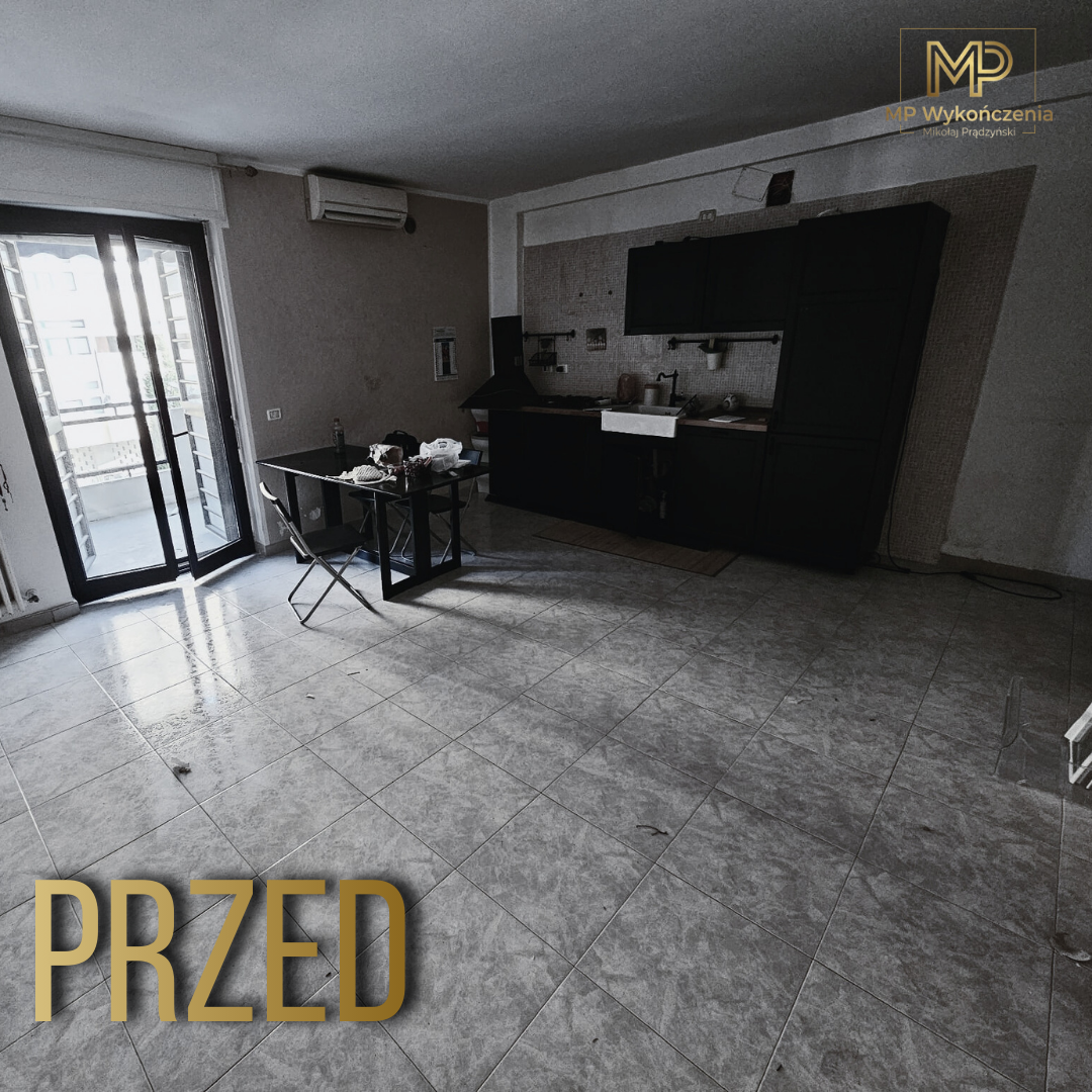 Salon przed remontem - puste pomieszczenie z nieukończoną kuchnią