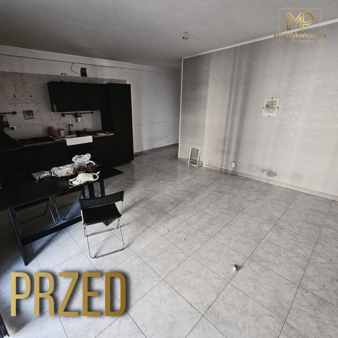 Salon przed remontem - puste pomieszczenie z nieukończoną kuchnią